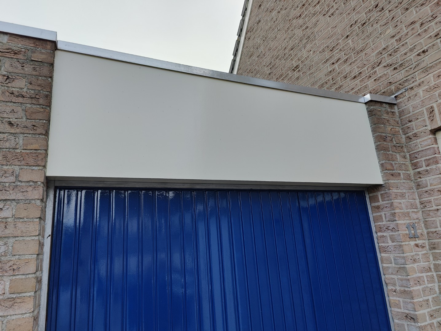 houten afdekking boven garagedeur